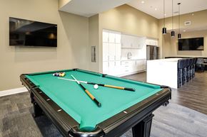 Omaha apartment for rent - A pool table with a green cloth and a white cue ball and rack.