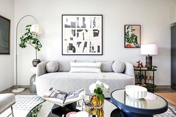Papillion apartment for rent - A living room with a grey couch, a coffee table, and a large abstract painting on the wall.