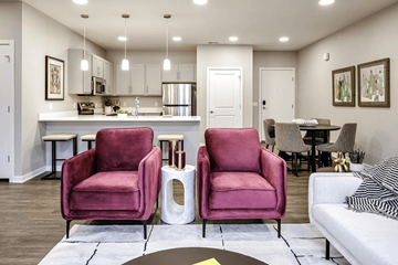 Omaha townhouse for rent - Two red chairs are in the middle of a white rug in a living room.