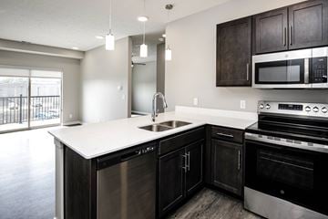 Omaha townhouse for rent - A modern kitchen with dark wood cabinets and stainless steel appliances.