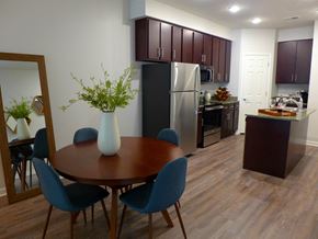 Omaha apartment for rent - a dining room and kitchen with a table and chairs and a refrigerator