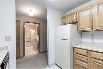 Lincoln apartment for rent - the spacious kitchen with white appliances and wooden cabinets in a renovated home