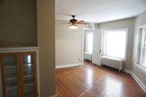 Omaha apartment for rent - an empty living room with a ceiling fan and a cabinet