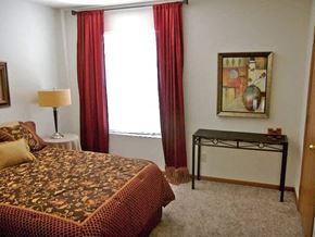 Fremont townhouse for rent - a bedroom with a bed and a window with red curtains