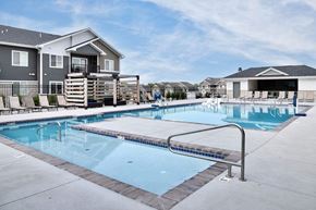 Lincoln apartment for rent - A swimming pool in front of a house with a deck and lounge chairs.