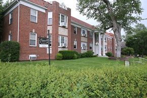 Omaha apartment for rent - a large brick building with a green lawn in front of it