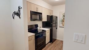 Macungie apartment for rent - A kitchen with a black fridge and stove top oven.