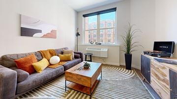 Allentown apartment for rent - A living room with a grey couch, a wooden coffee table, and a flat screen TV.