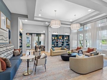 Venice apartment for rent - A living room with a blue sofa, a white coffee table, and a bookshelf filled with books.