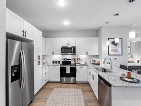 Venice apartment for rent - A modern kitchen with white cabinets and stainless steel appliances.
