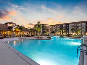 Venice apartment for rent - A large swimming pool in front of apartment buildings at dusk.