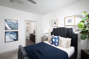 Rowlett apartment for rent - a bedroom with a large bed and pictures on the wall