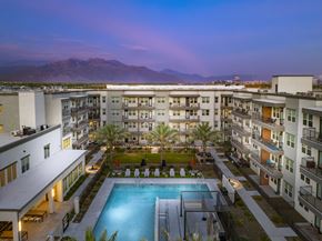 Mesa apartment for rent - A swimming pool is surrounded by apartment buildings.