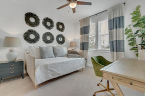 Kyle apartment for rent - a bedroom with a daybed, desk, and ceiling fan at a senior apartment community