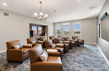 Queen Creek apartment for rent - A living room with brown leather chairs and a chandelier.