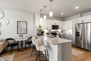Queen Creek apartment for rent - A kitchen with a table and chairs in the foreground and a refrigerator in the background.