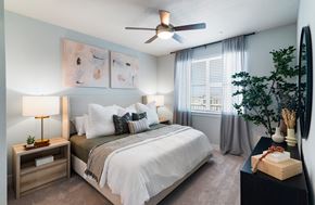 Queen Creek apartment for rent - A bedroom with a bed, nightstand, and a ceiling fan.