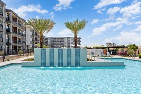 Glendale apartment for rent - a large pool with palm trees and an apartment building in the background