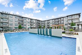 Mckinney apartment for rent - A large swimming pool in front of apartment buildings.