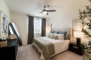 Mckinney apartment for rent - A bedroom with a large bed and a ceiling fan.