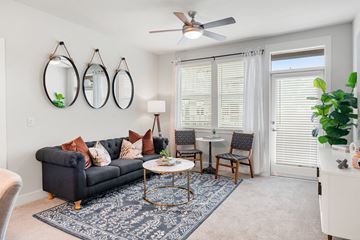 Mesa apartment for rent - a living room with a couch and a table and a ceiling fan