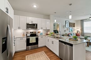 Mckinney apartment for rent - A modern kitchen with white cabinets and stainless steel appliances.