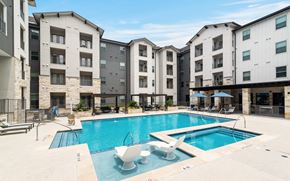 Austin apartment for rent - a resort-style swimming pool with lounge chairs and sitting areas covered by a wooden pergola at a senior apartment community