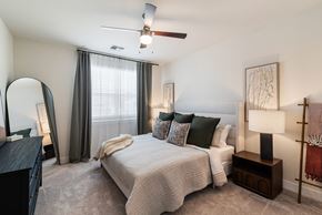 Mesa apartment for rent - A bedroom with a bed, nightstand, and a ceiling fan.