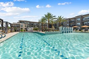 Queen Creek apartment for rent - A swimming pool with blue lane markers in front of apartment buildings.