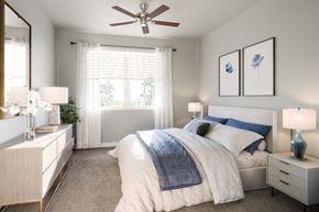 Naples apartment for rent - a bedroom with a queen-sized bed and ceiling fan and windows at a senior apartment community