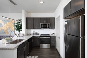 Cedar Hill apartment for rent - a kitchen with stainless steel appliances, granite countertops, and an island at a senior apartment community