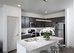 Rowlett apartment for rent - a kitchen with stainless steel appliances, and granite countertops and island