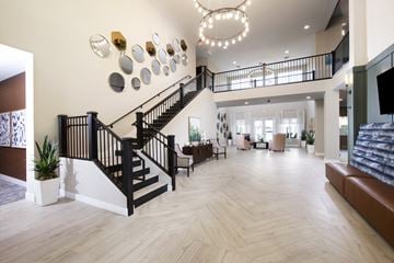 Surprise apartment for rent - a large living room with a staircase and a lobby with couches and chairs
