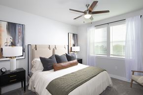 Surprise apartment for rent - a bedroom with a queen-sized bed, ceiling fan, and windows at a senior apartment community
