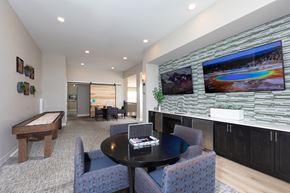 Goodyear apartment for rent - a game room with sitting areas and televisions at a senior apartment community