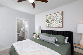 Goodyear apartment for rent - a bedroom with a queen-sized bed and ceiling fan at a senior apartment community