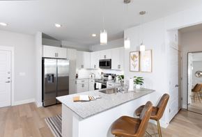 Goodyear apartment for rent - a kitchen with stainless steel appliances and granite countertops at a senior apartment community
