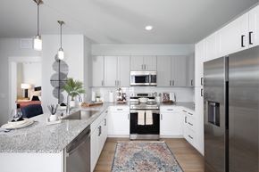 Henderson apartment for rent - a kitchen with stainless steel appliances and granite countertops at a senior apartment community