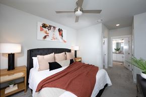Henderson apartment for rent - a bedroom with a queen-sized bed and ceiling fan at a senior apartment community