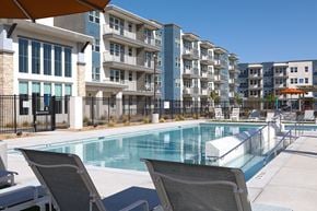 Henderson apartment for rent - a resort-style pool and lounge chairs at a senior apartment community