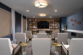 Las Vegas apartment for rent - a media room with lounge chairs and large television at a senior apartment community