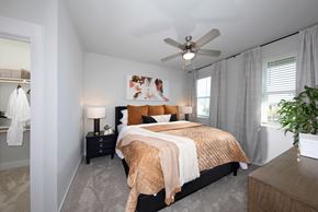 Las Vegas apartment for rent - a bedroom with a queen-sized bed, ceiling fan, and windows at a senior apartment community