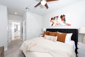 Glendale apartment for rent - a bedroom with a queen-sized bed and ceiling fan at a senior apartment community