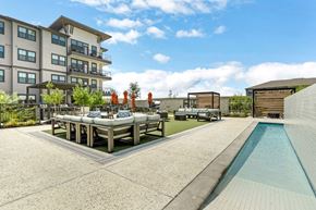 Kyle apartment for rent - an outdoor dining area with tables and chairs next to a resort-style pool at a senior apartemtn community