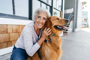 Henderson apartment for rent - an older woman sitting with her dog outside at a senior apartment community