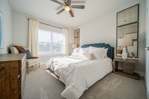 Charlotte apartment for rent - a bedroom with a queen-sized bed, ceiling fan and windows at a senior apartment community
