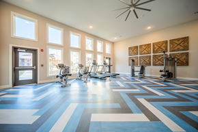 Charlotte apartment for rent - a gym with fitness machines and equipment and a large ceiling fan at a senior apartment community