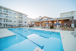 Charlotte apartment for rent - a resort-style pool with lounge areas at a senior apartment community
