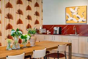 Naples apartment for rent - A kitchen with a wooden table and chairs, a sink, and a painting on the wall.