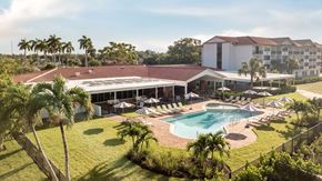 Naples apartment for rent - A large building with a pool in front of it.